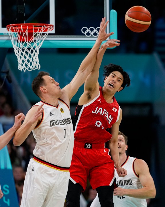 Johannes Voigtmann, of Germany, and Hirotaka Yoshii, of Japan, go up for a rebound in a men's basketball game at the 2024 Summer Olympics, Saturday, July 27, 2024 in Villeneuve-d'Ascq, France. (AP Photo/Mark J. Terrill)