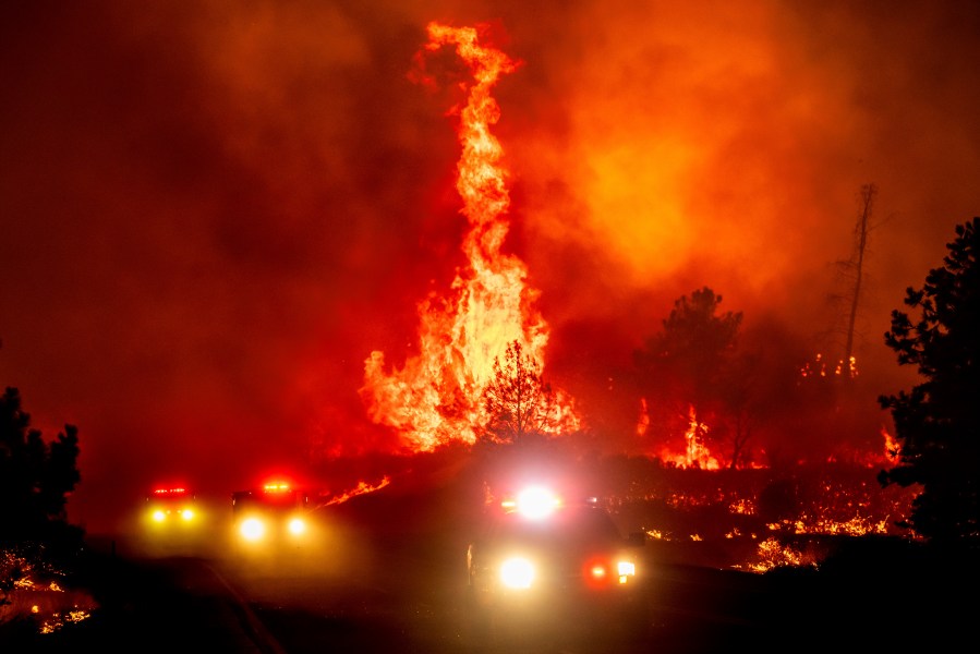 Flames leap above fire vehicles as the Park Fire jumps Highway 36 near Paynes Creek in Tehama County, Calif., Friday, July 26, 2024. (AP Photo/Noah Berger)