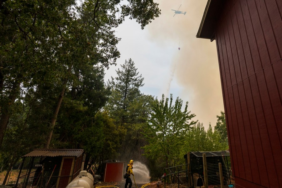 Volunteer firefighter Craig Klieb sprays water around his house as the Park Fire burns nearby in Forest Ranch, Calif., Saturday, July 27, 2024. Until a few years ago, (AP Photo/Nic Coury)