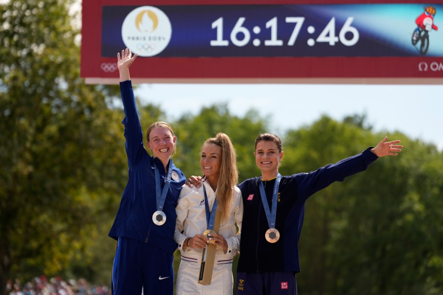 Pauline Ferrand Prevot, of France, centre, winner of the women's mountain bike cycling event, poses with her gold medal flanked by silver medallist Haley Batten, of United States, left, and bronze medallist Jenny Rissveds, of Sweden, at the 2024 Summer Olympics, Sunday, July 28, 2024, in Elancourt, France. (AP Photo/George Walker IV)