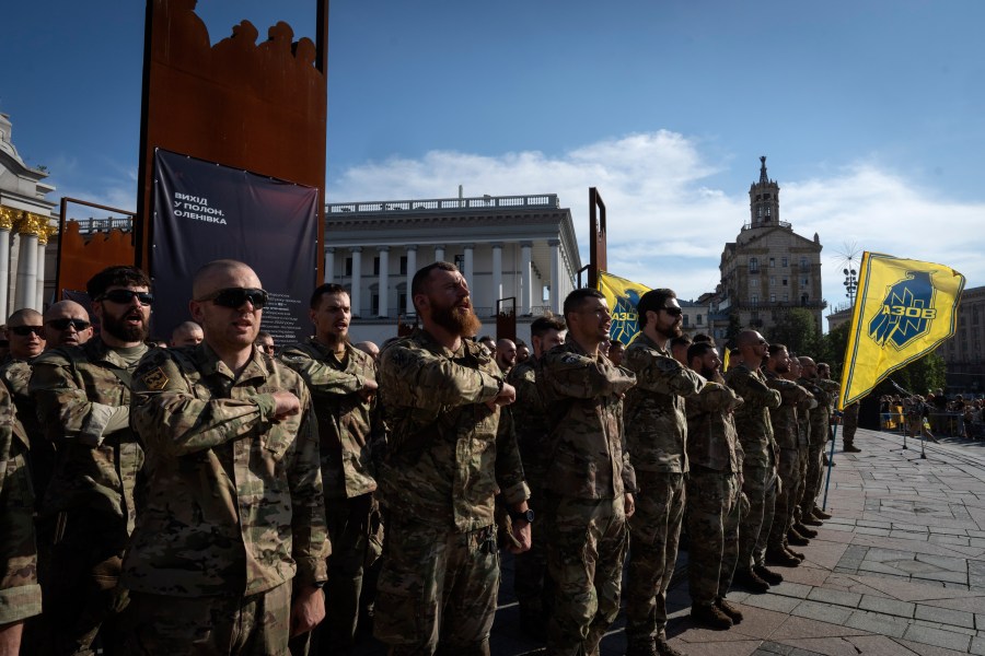 Soldiers of Ukraine's Azov battalion pray at a rally demanding to free Ukrainian prisoners of war who are held in captivity in Russia, at Independence Square in Kyiv, Ukraine, Sunday, July 28, 2024. Several thousand people and soldiers gathered to commemorate the second anniversary of a Russia-orchestrated explosion that killed more than 50 Ukrainian prisoners of war in the Russian-held Olenivka prison barracks. (AP Photo/Efrem Lukatsky)