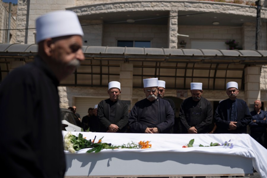 Druze clergymen pray during the funeral for Guevara Ibrahim, 11, one of 12 children and teens killed in a rocket strike on a soccer field, in the village of Majdal Shams, in the Israeli-annexed Golan Heights, Monday, July 29, 2024. (AP Photo/Leo Correa)