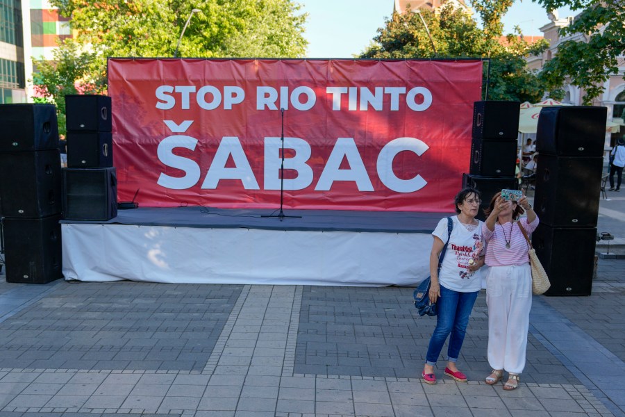 Two woman take a selfie in front of a podium prior to a protest in Sabac, Serbia, Monday, July 29, 2024. Thousands of people rallied in several towns in Serbia to protest a lithium excavation project the Balkan country's government recently signed with the European Union. (AP Photo/Darko Vojinovic)