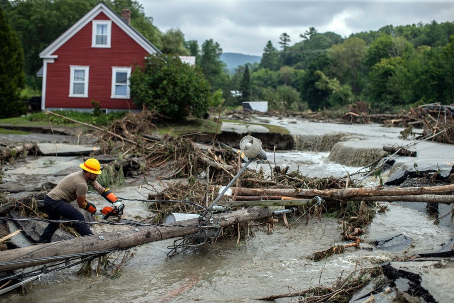 Zac Drown, of Lyndon Electric Company, clears debris amid flood damage in Lyndon, Vt., Tuesday, July 30, 2024. (AP Photo/Dmitry Belyakov)