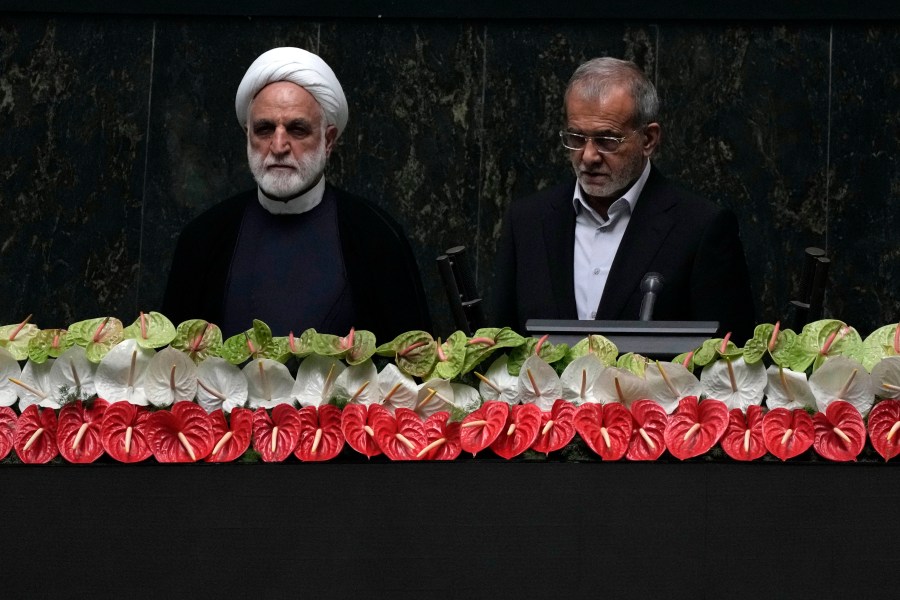 Newly-elected President Masoud Pezeshkian, right, takes his oath, as Judiciary Chief Gholamhossein Mohseni Ejehi listens during a ceremony at the parliament in Tehran, Iran, Tuesday, 30, 2024. (AP Photo/Vahid Salemi)