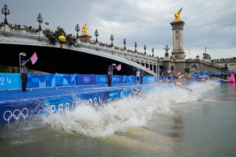 Athletes dive into the water for the start of the women's individual triathlon competition at the 2024 Summer Olympics, Wednesday, July 31, 2024, in Paris, France. (AP Photo/Vadim Ghirda)