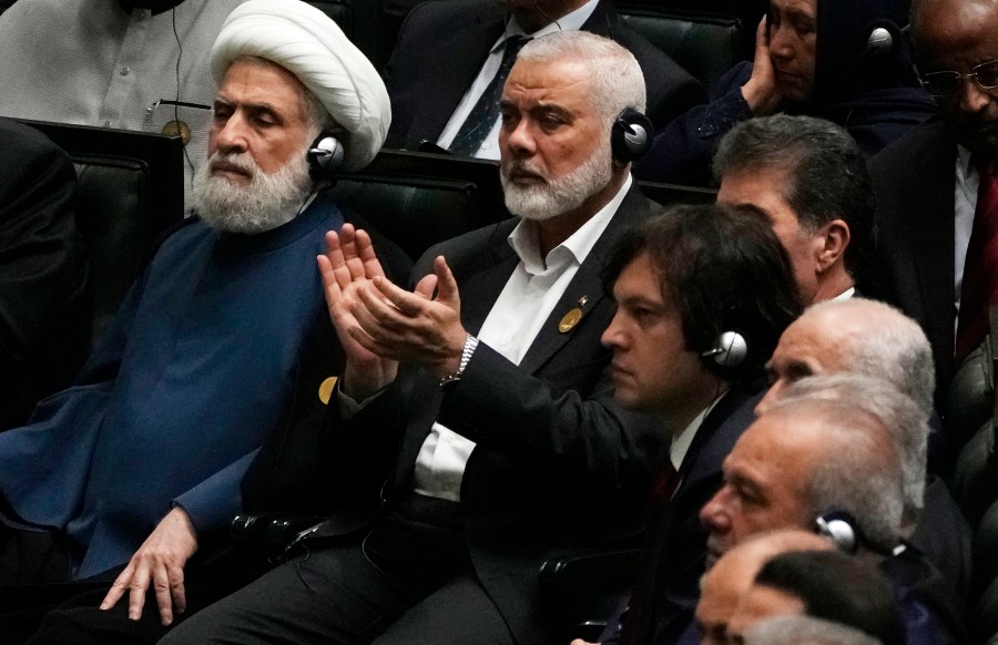 Hamas chief Ismail Haniyeh claps as newly-elected Iranian President Masoud Pezeshkian speaks while deputy leader of the Lebanese militant group Hezbollah, Sheikh Naim Kassem, left, sits during the swearing-in ceremony of Pezeshkian at the Iranian parliament, in Tehran, Iran, Tuesday, July 30, 2024. (AP Photo/Vahid Salemi)