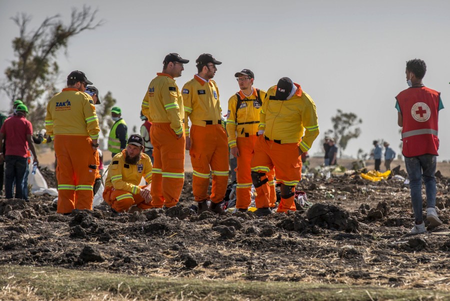 FILE - Investigators from Israel examine wreckage on March 12, 2019 at the scene of the Ethiopian Airlines Boeing 737 Max 8 crash near Bishoftu, or Debre Zeit, south of Addis Ababa, in Ethiopia. Families of people killed in the 737 Max crashes formally asked a federal judge in Texas to reject Boeing's plea deal with the Justice Department. (AP Photo/Mulugeta Ayene, File)