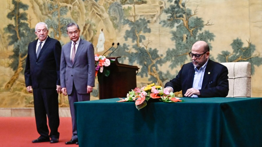 Mussa Abu Marzuk (R), senior member of the Palestinian Islamist movement Hamas (R) signs a document as China's Foreign Minister Wang Yi (C) and Mahmoud al-Aloul, Vice Chairman of the Central Committee of Palestinian organisation and political party Fatah, look on during the signing of the "Beijing declaration" at the Diaoyutai State Guesthouse in Beijing on July 23, 2024. China's Foreign Minister Wang Yi on July 23 hailed an agreement by 14 Palestinian factions to set up an "interim national reconciliation government" to govern Gaza after the war. Palestinian factions including Hamas and Fatah met in Beijing this week in a renewed bid for reconciliation. (Photo by Pedro PARDO / POOL / AFP) (Photo by PEDRO PARDO/POOL/AFP via Getty Images)