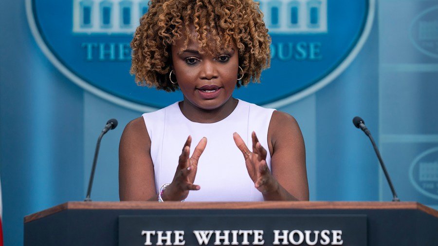 White House press secretary Karine Jean-Pierre gestures while delivering a press briefing.