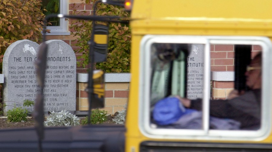 A school bus makes its way past a marker depicting the Ten Commandments outside of Peebles High School November 20,2002 in Peebles, Ohio. A federal Appeals Court has ordered the school to remove the marker. (Photo by Mike Simons/Getty Images)