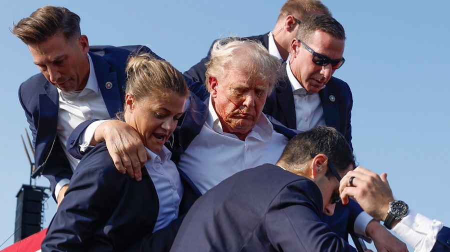 Republican presidential candidate former President Donald Trump is rushed offstage by U.S. Secret Service agents after being grazed by a bullet during a rally on July 13, 2024 in Butler, Pennsylvania. Butler County district attorney Richard Goldinger said the shooter is dead after injuring former U.S. President Donald Trump, killing one audience member and injuring another in the shooting. (Photo by Anna Moneymaker/Getty Images)