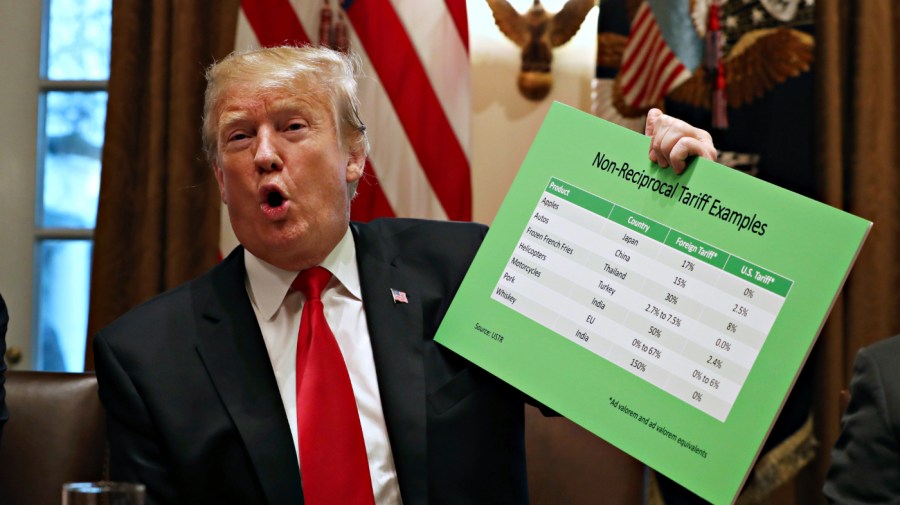 President Donald Trump holds up examples of tariffs, Thursday, Jan. 24, 2019, in the Cabinet Room of the White House in Washington. (AP Photo/Jacquelyn Martin)