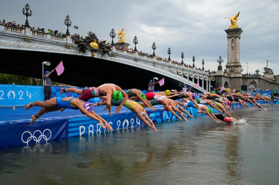 Athletes dive into the water for the start of the women's individual triathlon competition at the 2024 Summer Olympics, Wednesday, July 31, 2024, in Paris, France. (AP Photo/Vadim Ghirda)