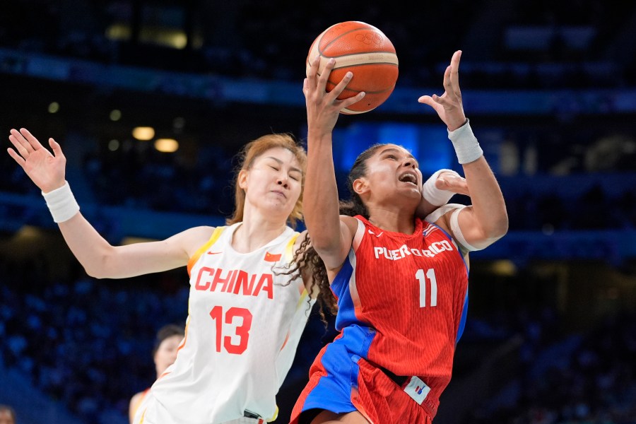 Puerto Rico's Sofia Roma, right, shoots as China's Sun Mengran defends during a women's basketball game at the 2024 Summer Olympics, Saturday, Aug. 3, 2024, in Villeneuve-d'Ascq, France. (AP Photo/Michael Conroy)