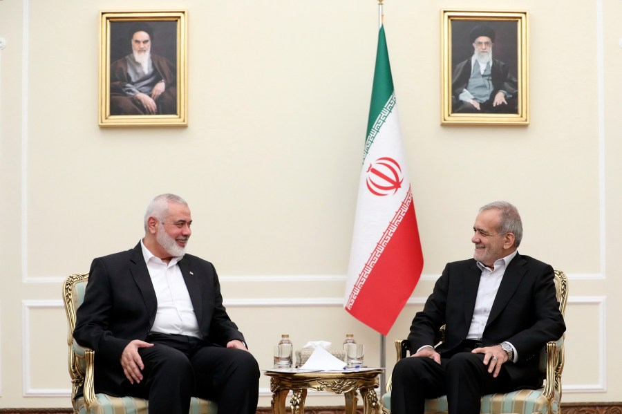 In this photo released by the Iranian Presidency Office, President Masoud Pezeshkian, right, meets Hamas chief Ismail Haniyeh, at the President's office in Tehran, Iran, Tuesday, July 30, 2024. (Iranian Presidency Office via AP)