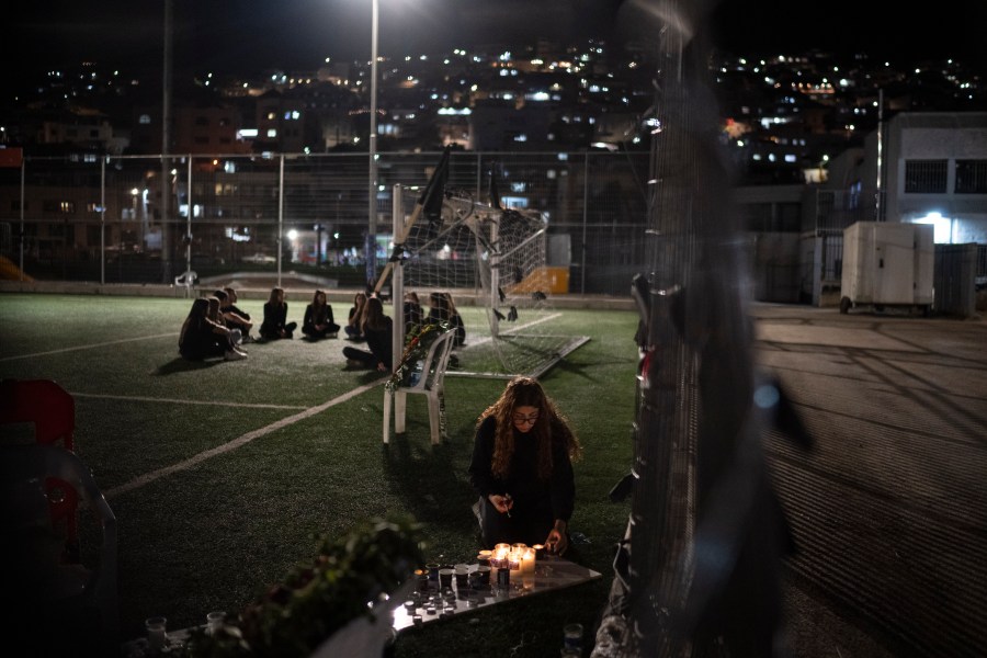 FILE - A young woman lights a candle in memory of the twelve children and teens killed by rocket strike at a soccer field in the town of Majdal Shams, in the Israeli-annexed Golan Heights, Thursday, Aug. 1, 2024. (AP Photo/Leo Correa, File)