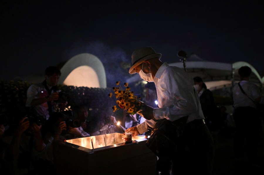 CORRECTS TO 79TH NOT 78TH - A man places incense in front of the cenotaph dedicated to the victims of the atomic bombing, early in the morning before an annual ceremony marking the 79th anniversary of the world's first atomic bombing at the Peace Memorial Park in Hiroshima, western Japan, Tuesday, Aug. 6, 2024. (Yu Nakajima/Kyodo News via AP)