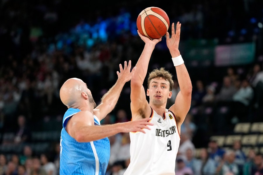 Franz Wagner, right, of Germany, shoots as Nick Calathes, of Greece, defends during a men's basketball game at the 2024 Summer Olympics, Tuesday, Aug. 6, 2024, in Villeneuve-d'Ascq, France. (AP Photo/Michael Conroy)