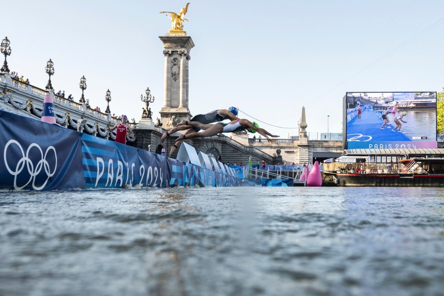 Athletes jump into the water to compete in the swimming race in the Seine river, during the mixed relay triathlon, at the 2024 Olympic Games, in Paris, France, Monday, Aug. 5, 2024. (Martin Bureau/Pool Photo via AP)