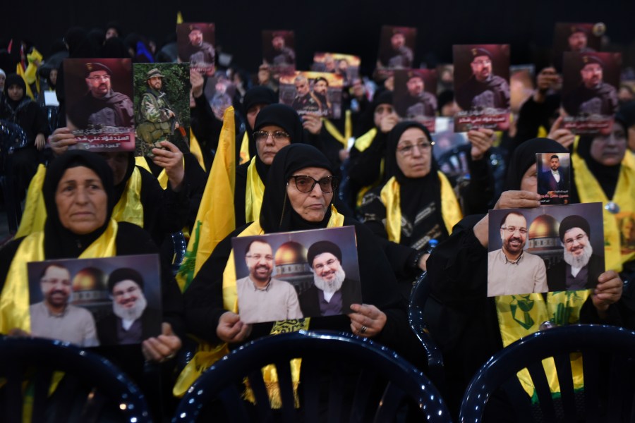 Hezbollah supporters hold portraits that show Hezbollah leader Sayyid Hassan Nasrallah and one of his commander Fouad Shukur, who was killed by an Israeli airstrike last week, during a ceremony to commemorate his death in Beirut, Lebanon, Tuesday, Aug. 6, 2024. (AP Photo/Mustafa Jamalddine)