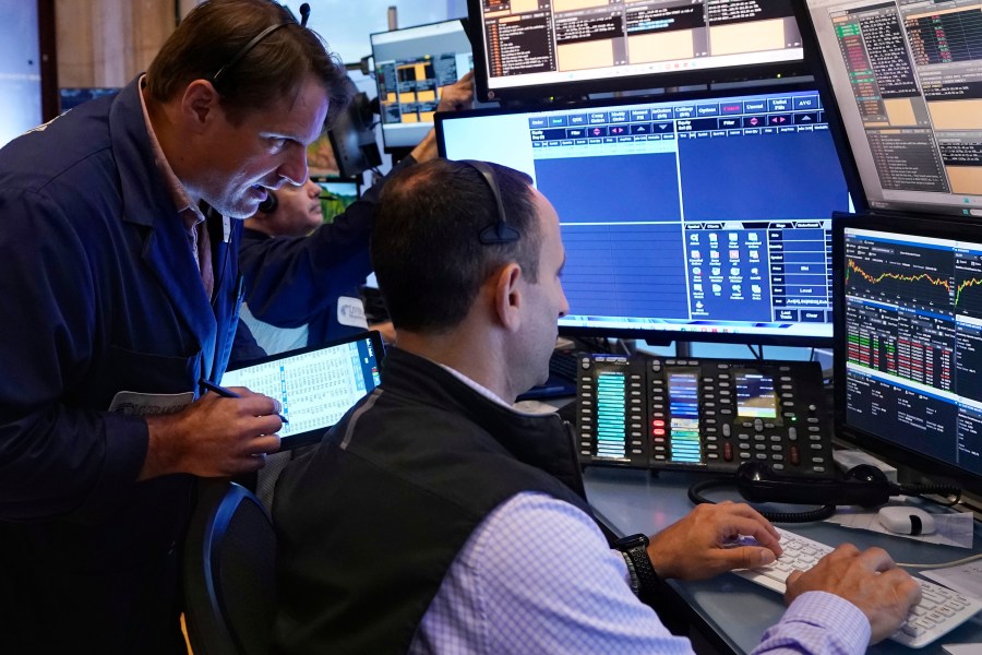 Trader Michael Milano. left, works with colleagues on the floor of the New York Stock Exchange, Wednesday, Aug. 7, 2024. (AP Photo/Richard Drew)