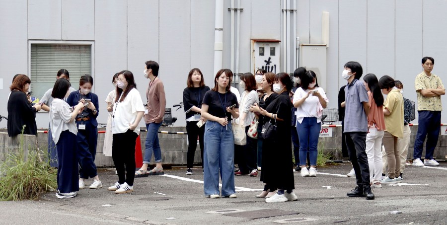 People take shelter outside building following an earthquake in Miyazaki, western Japan, Thursday, Aug. 8, 2024.(Kyodo News via AP)