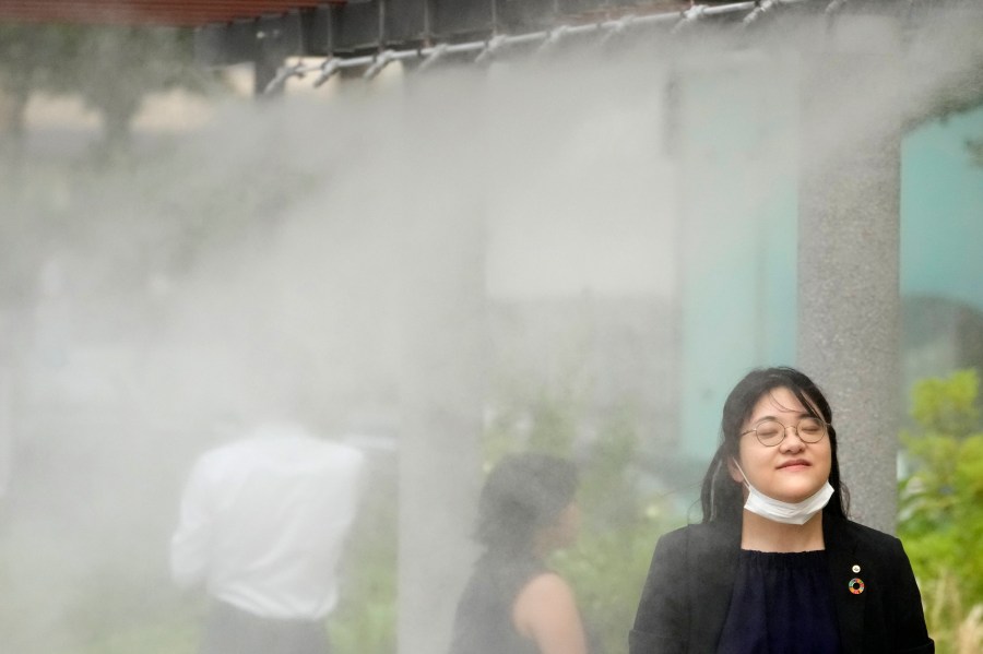 FILE - People cool off at a cooling mist spot on July 4, 2024, in Tokyo. (AP Photo/Shuji Kajiyama, File)