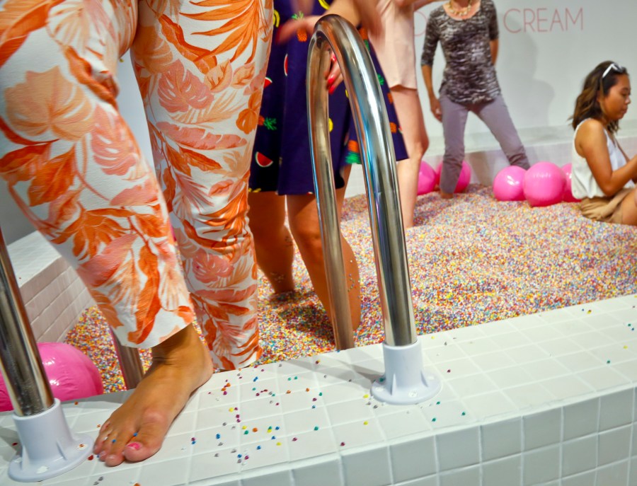 FILE - Visitors walk into a large pool filled with faux confetti-colored sprinkles, the biggest attraction of ice cream-themed works of art previewed at the Museum of Ice Cream, July 28, 2016, in New York. (AP Photo/Bebeto Matthews, File)