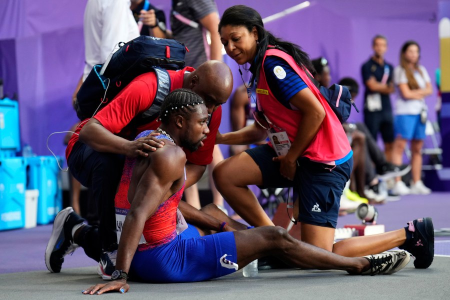 Noah Lyles, of the United States, is treated by medical staff following the men's 200-meters final at the 2024 Summer Olympics, Thursday, Aug. 8, 2024, in Saint-Denis, France. (AP Photo/Petr David Josek)