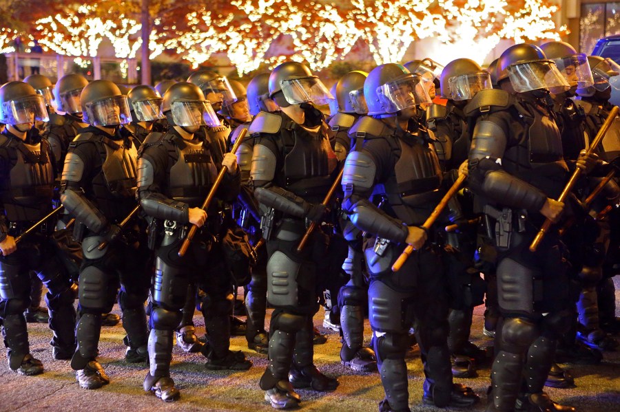 FILE - Atlanta police line up in riot gear as demonstrators protest in the wake of the grand jury decision not to indict Ferguson police officer Darren Wilson in the fatal shooting of Michael Brown, Nov. 25, 2014, in Atlanta. (AP Photo/Atlanta Journal-Constitution, Curtis Compton, File)