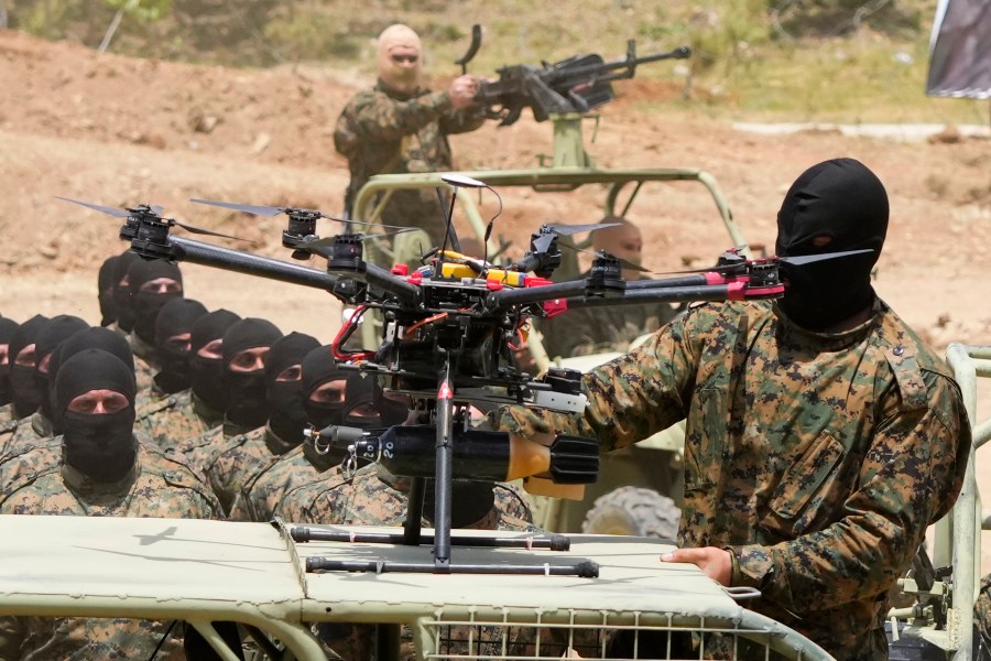 A Hezbollah fighter stands next to an armed drone during a training exercise in Aaramta village in the Jezzine District, southern Lebanon, on May 21, 2023. . (AP Photo/Hassan Ammar)