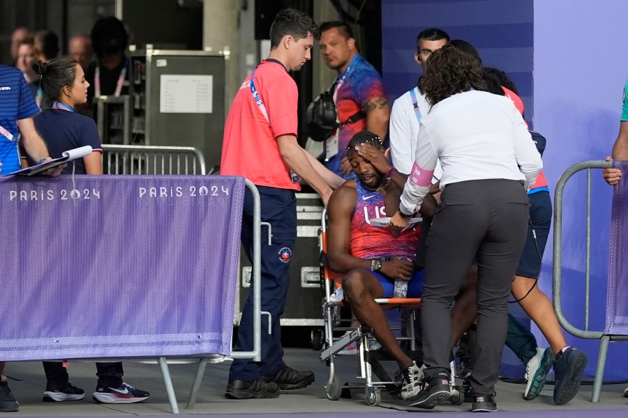 Noah Lyles, of the United States, is helped off the track after the men's 200-meter final at the 2024 Summer Olympics, Thursday, Aug. 8, 2024, in Saint-Denis, France. (AP Photo/Matthias Schrader)