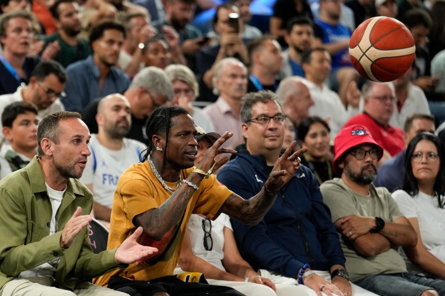 Travis Scott tosses the ball back in before the France vs' Germany game during a men's semifinals basketball game at Bercy Arena at the 2024 Summer Olympics, Thursday, Aug. 8, 2024, in Paris, France. (AP Photo/Mark J. Terrill)