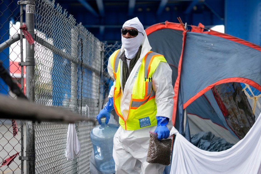 A member of San Francisco Public Works clears a homeless encampment Thursday, Aug. 1, 2024, in San Francisco. (AP Photo/Godofredo A. Vásquez)