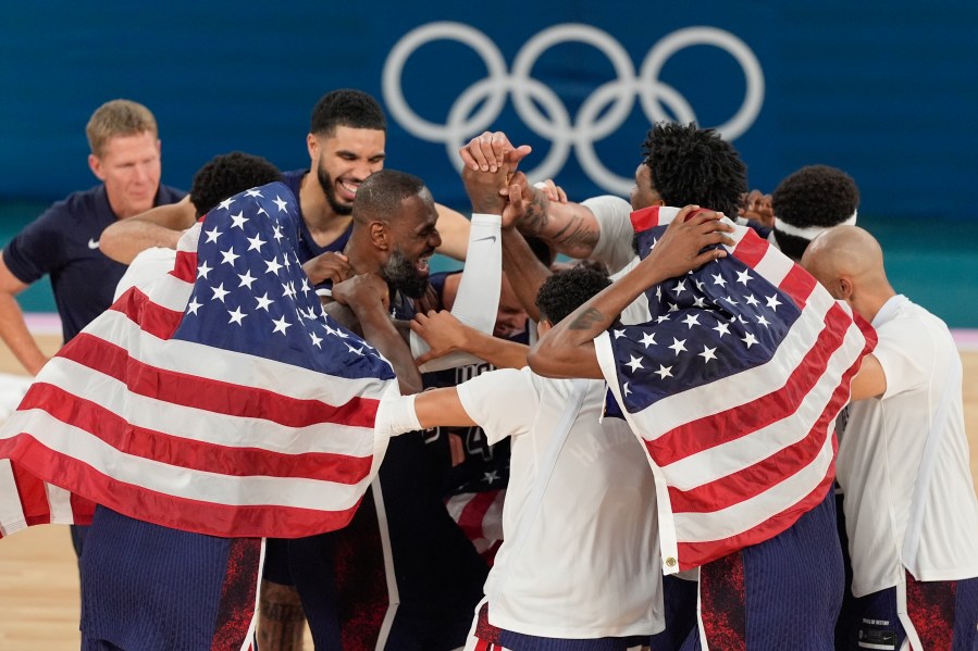 The United States basketball team reacts after winning a men's gold medal basketball game against France at Bercy Arena at the 2024 Summer Olympics, Saturday, Aug. 10, 2024, in Paris, France. (AP Photo/Michael Conroy)