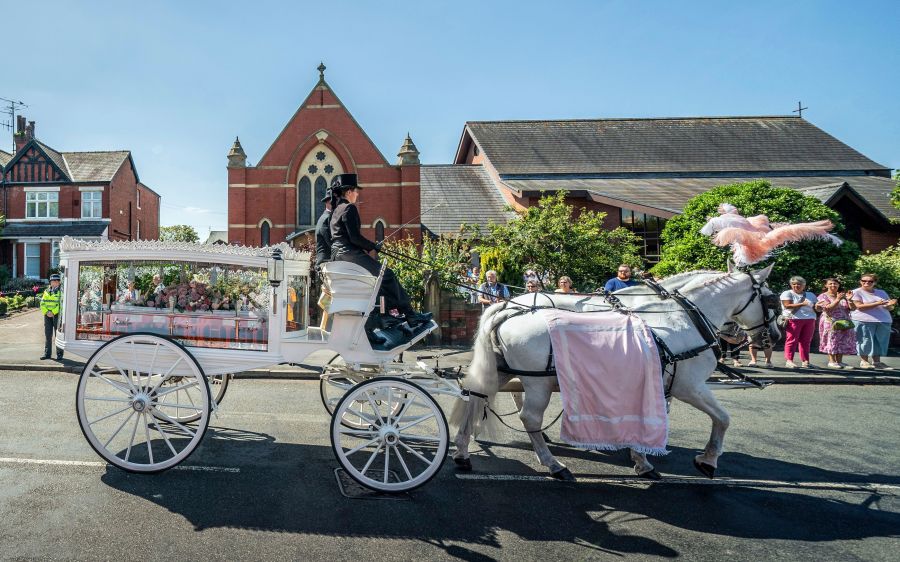 The horse-drawn carriage carrying the coffin of stabbing victim Alice da Silva Aguiar arrives for her funeral at St Patrick's Church, Southport, England, Sunday Aug. 11, 2024. (Danny Lawson/PA via AP)