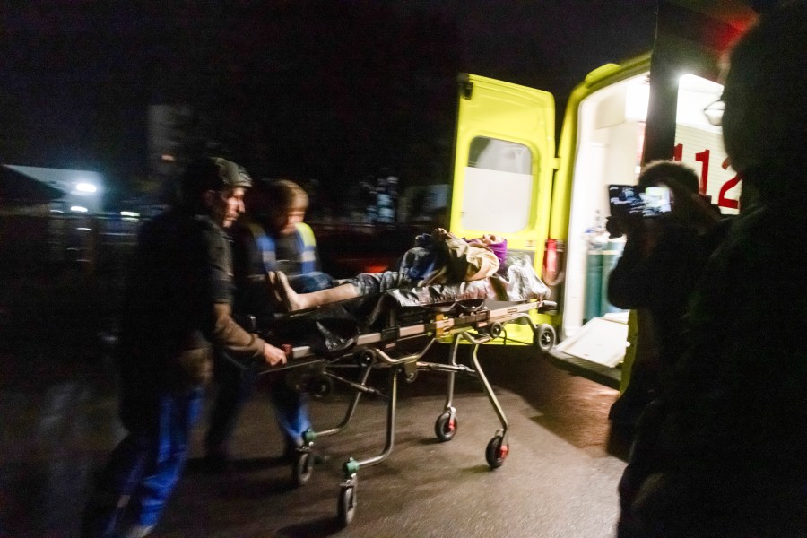 Russian Emergency paramedics roll a stretcher with a resident of an apartment building damaged after shelling by the Ukrainian side into an ambulance in Kursk, Russia, Sunday, Aug. 11, 2024. (AP Photo)