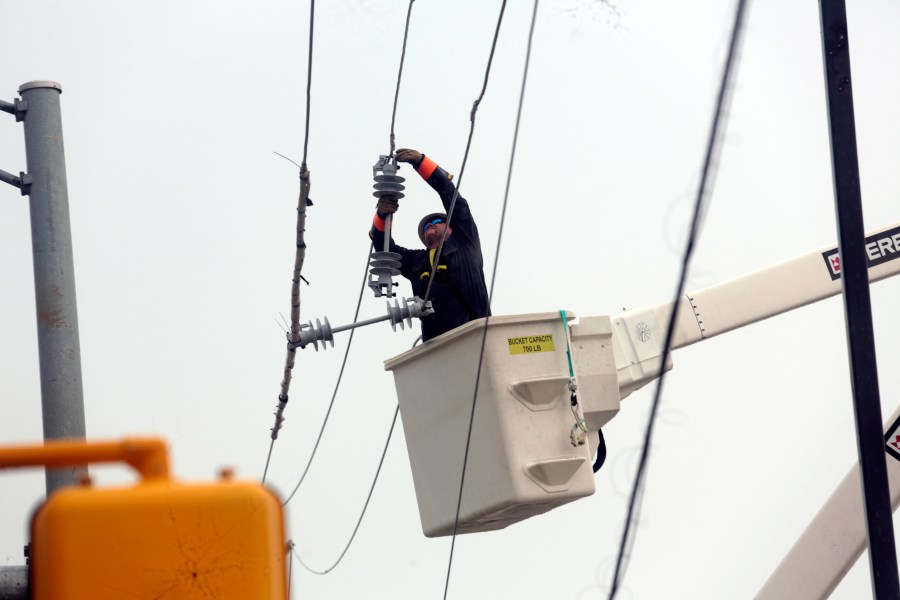 FILE - Utility crews work to restore electricity in Houston, July 11, 2024. (AP Photo/Lekan Oyekanmi, File)