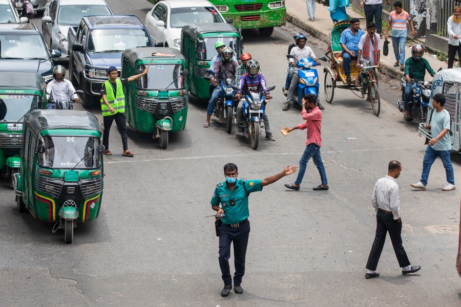 A police officer regulates a busy traffic intersection in Dhaka, Bangladesh, Monday, Aug. 12, 2024. (AP Photo/Rajib Dhar)