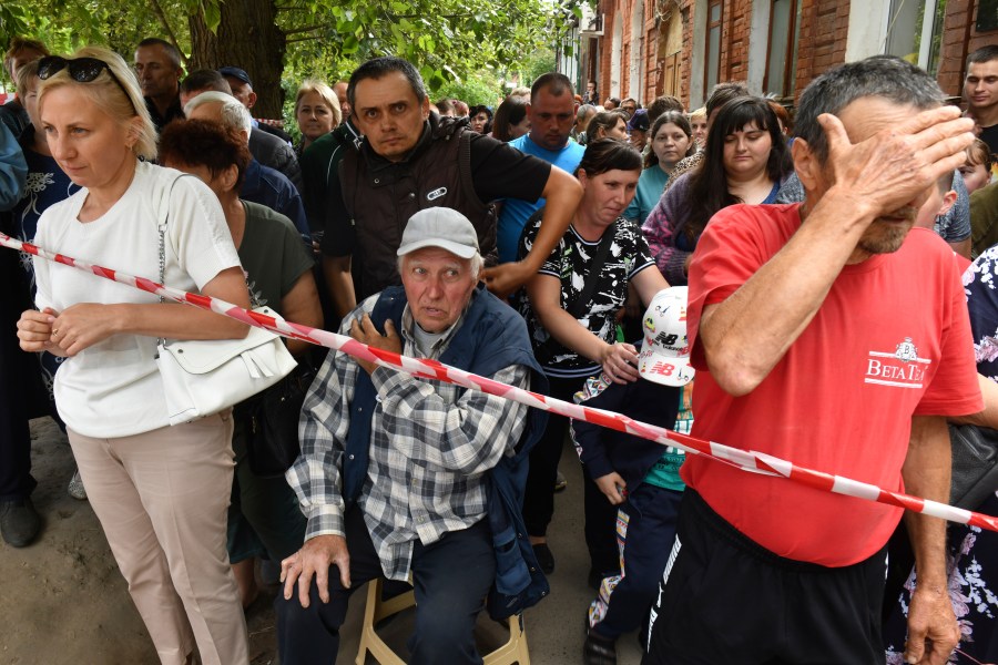 People evacuated from a fighting between Russian and Ukrainian forces queue to receive humanitarian aid at a distribution center in Kursk, Russia, Monday, Aug. 12, 2024. (AP Photo)