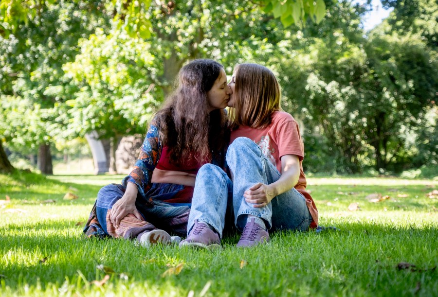 Freed Russian artist Sasha Skochilenko, left, and her partner, Sofya Subbotina, kiss in a park in Koblenz, Germany, Saturday, Aug. 10, 2024. (AP Photo/Michael Probst)