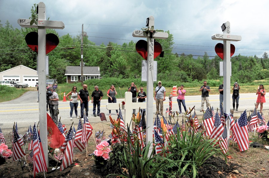 FILE - People view a memorial at the site, July 6, 2019, where seven bikers riding with the Jarheads Motorcycle Club were killed in a collision in Randolph, N.H. (Paul Hayes/Caledonian-Record via AP, File)