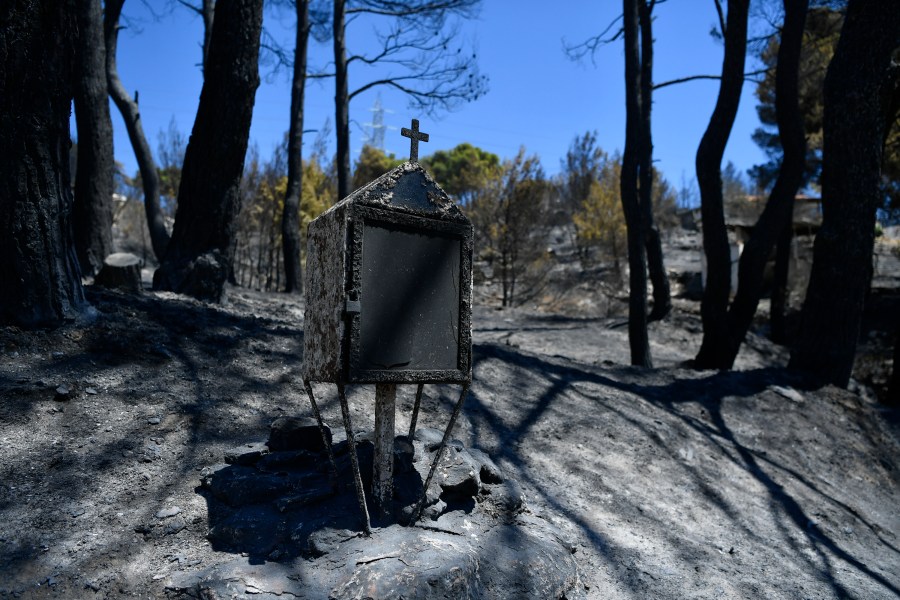 A burned roadside shrine stands in Nea Penteli suburb of Athens, on Tuesday, Aug. 13, 2024, following a major wildfire that has burned into the northern suburbs of the Greek capital. (AP Photo/Michael Varaklas)