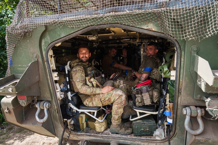 Ukrainian servicemen sit inside their APC after returning from Russian Kursk region, near Russian-Ukrainian border, Sumy region, Ukraine, Wednesday, Aug. 14, 2024. (AP Photo/Evgeniy Maloletka)