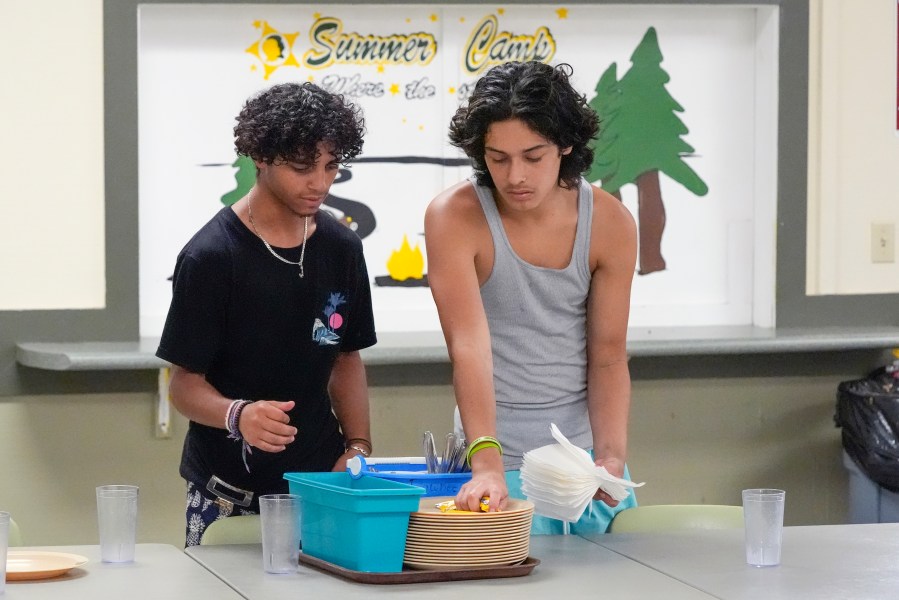 Jeremiah Monserrate, left, and Joaquin Ortiz set tables as part of kitchen duty before lunch at the Florida Sheriff's Youth Ranch Thursday, Aug. 1, 2024, in Pierson, Fla. (AP Photo/John Raoux)