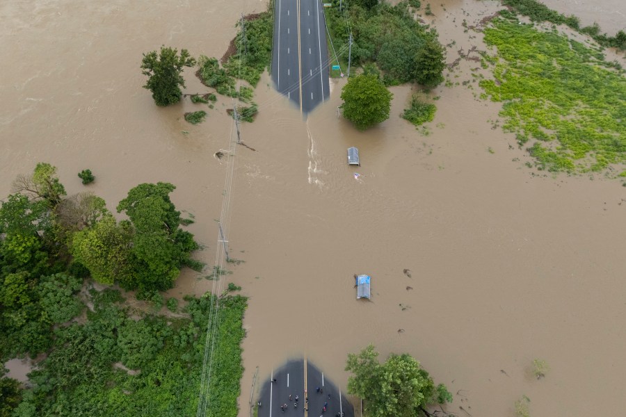 La Plata river floods a road after Tropical Storm Ernesto passed through Toa Baja, Puerto Rico, Wednesday, Aug. 14, 2024. (AP Photo/Alejandro Granadillo)