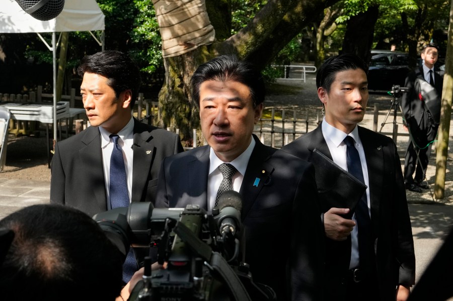 Japanese Defense Minister Minoru Kihara, center, speaks to media members after offering prayer for the war dead at Yasukuni Shrine in Tokyo, Japan, Thursday, Aug. 15, 2024, as the country marks the 79th anniversary of its defeat in the World War II. (AP Photo/Hiro Komae)