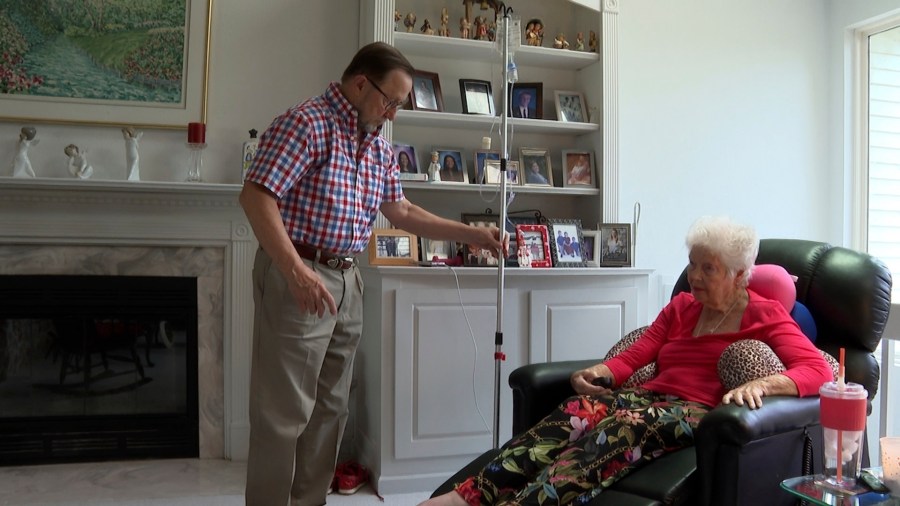 Patrick Fleming, left, helps administer medications to his wife Sue Fleming after she was hospitalized for listeria, Thursday, Aug. 8, 2024 in High Ridge, Mo. (AP Photo by Nick Ingram)