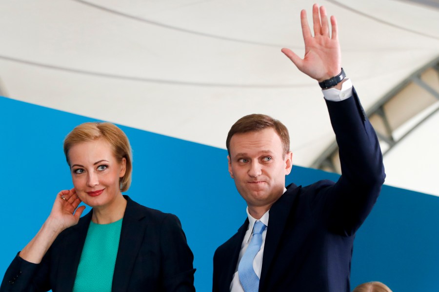 FILE - Russian opposition leader Alexei Navalny and his wife Yulia attend a meeting where he was nominated for the presidential election race, in Moscow, Russia, Dec. 24, 2017. (AP Photo/Pavel Golovkin, File)